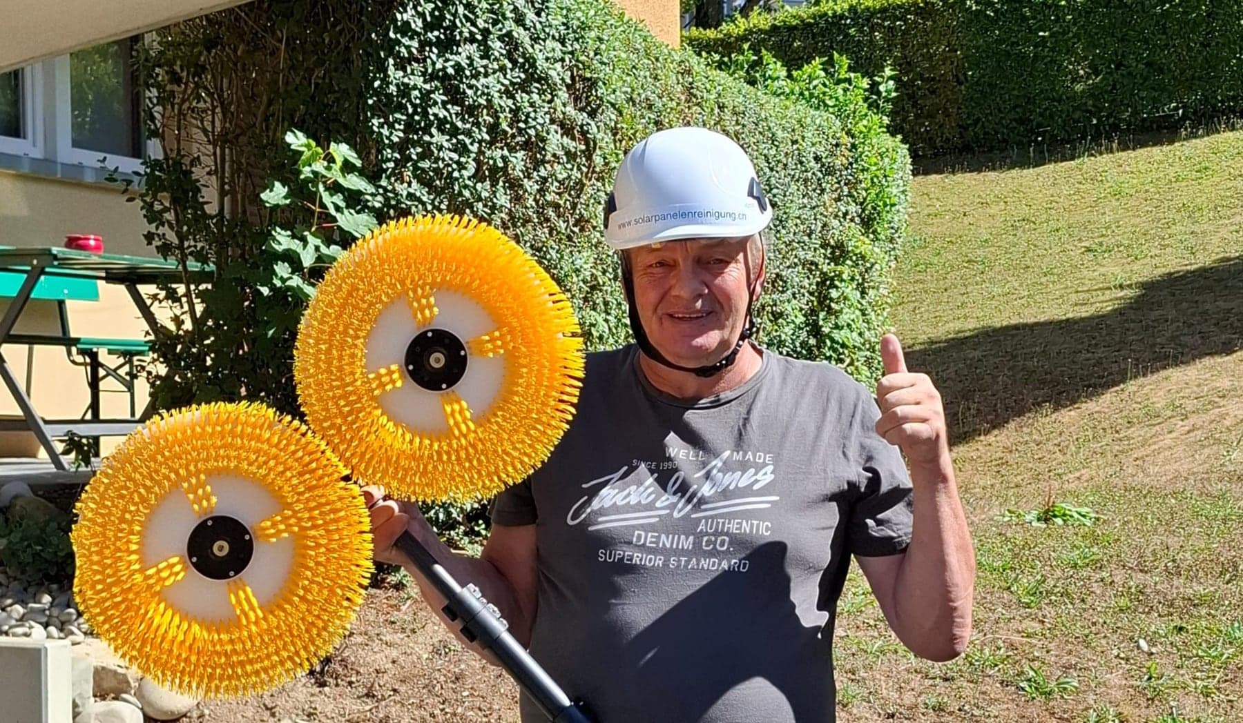 Erich Garone — Inhaber der Solarpanelenreinigung E. Garone, mit Firmenhelm und den beiden gelben Reinigungsbürsten am Teleskopstab
